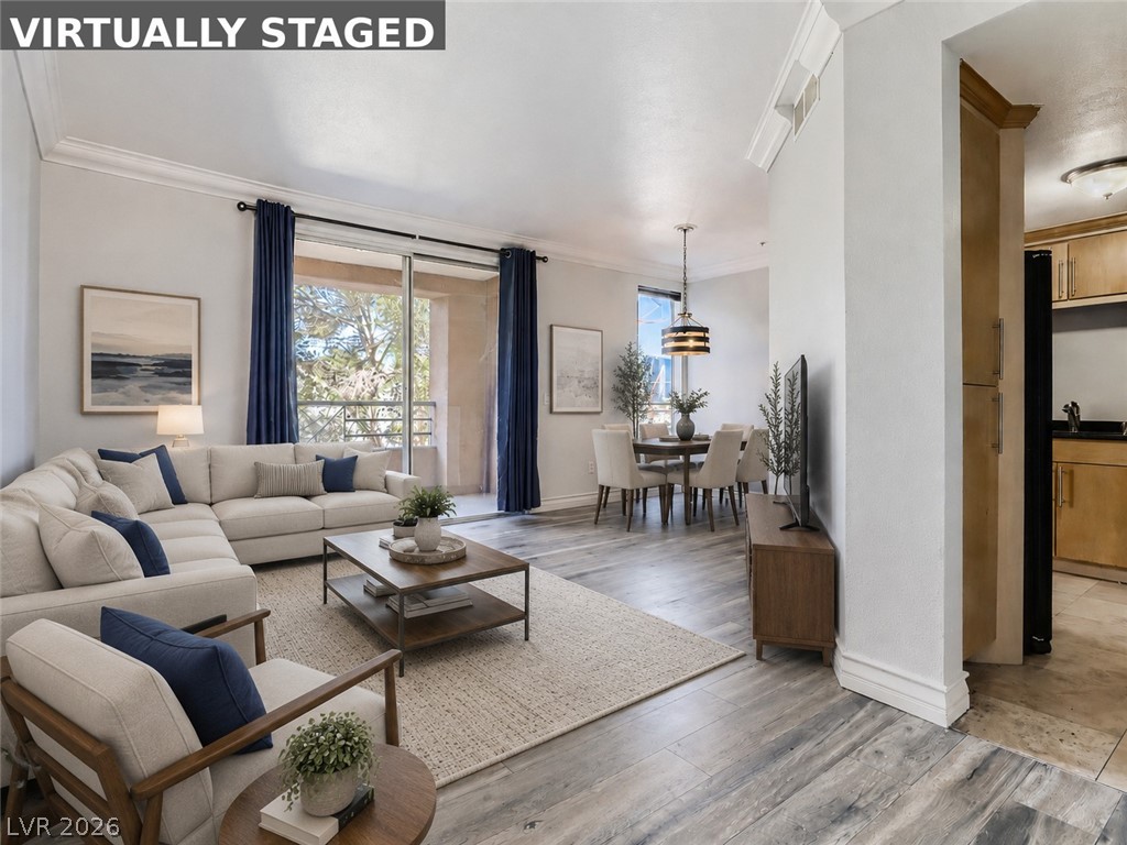 260 East Flamingo Road, Unit 220 Las Vegas, NV 89169 - Photo 28 of 32 Natural light floods this inviting living space, connecting to a charming dining area and balcony.