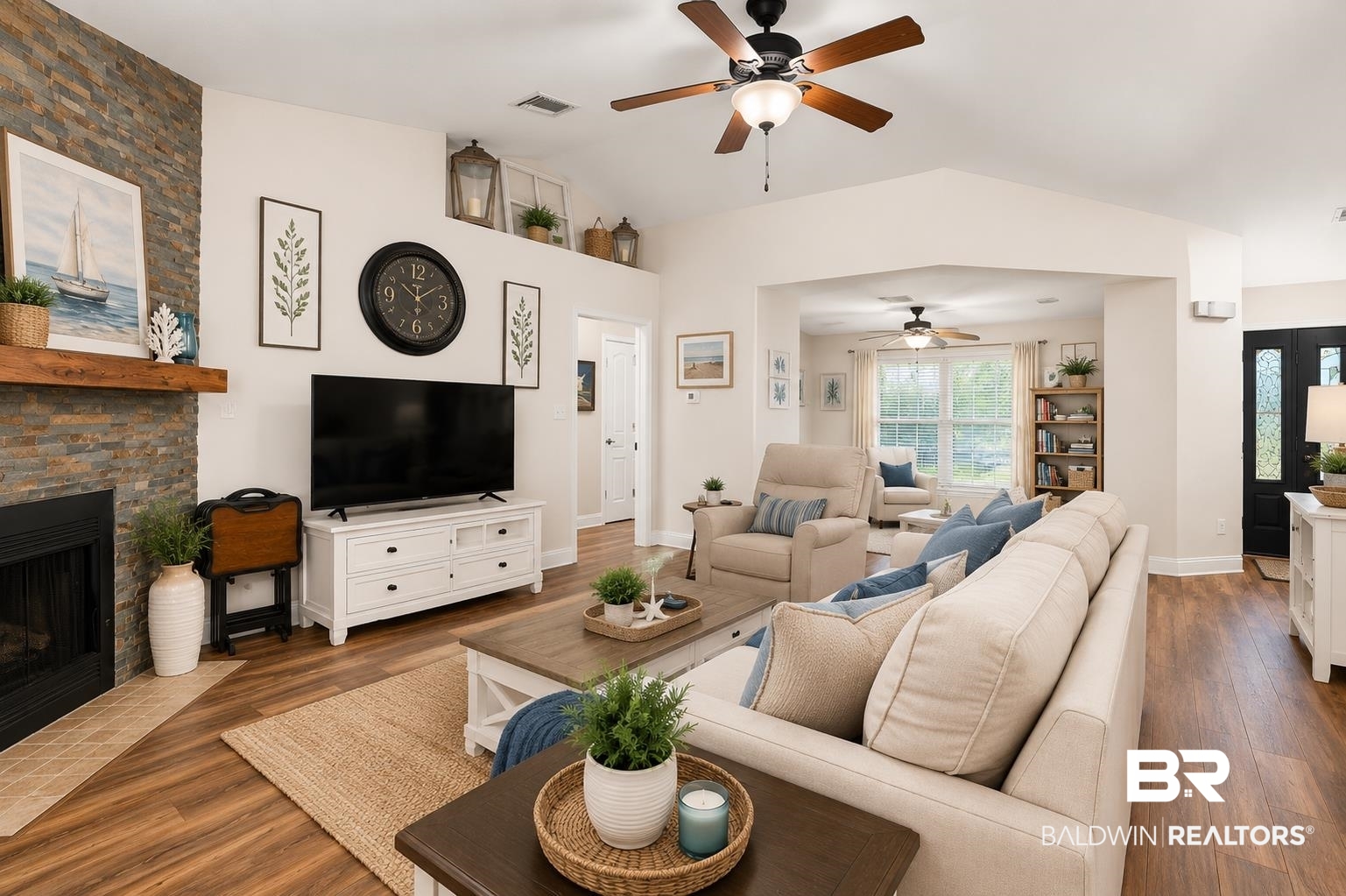 562 Vestige Mews Foley, AL 36535 - Photo 9 of 54 AI Edited Image: Open-concept living area featuring vaulted ceilings, wood-finish flooring, and a stacked stone fireplace with a wood mantle