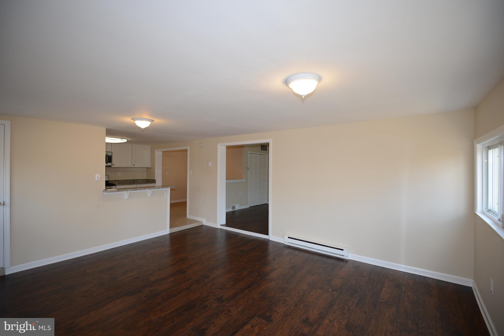 7500 Greenleaf Road Landover, MD 20785 - Photo 5 of 22 a view of an empty room with wooden floor and a window