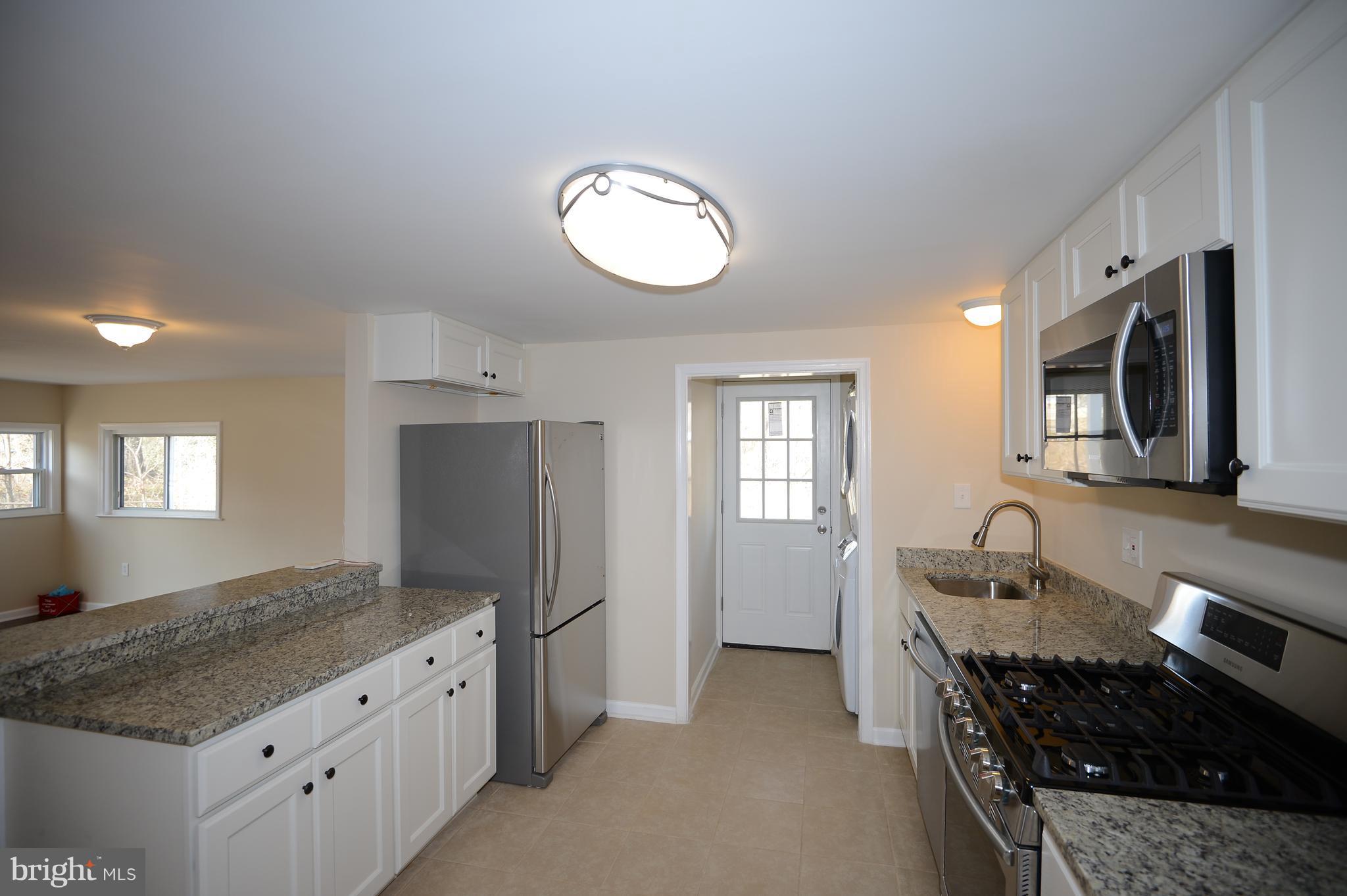 7500 Greenleaf Road Landover, MD 20785 - Photo 8 of 22 a kitchen with granite countertop a stove and a sink