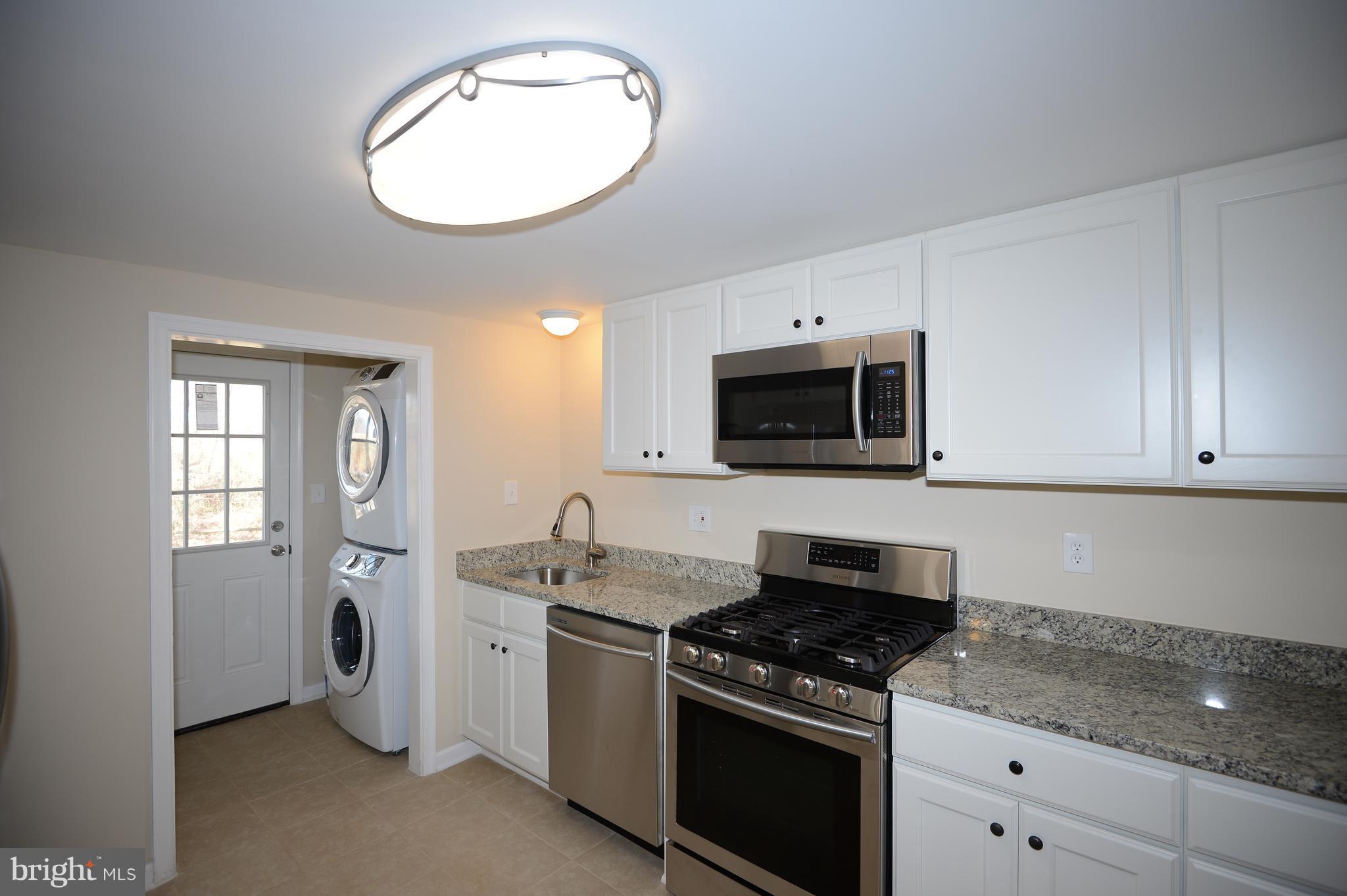 7500 Greenleaf Road Landover, MD 20785 - Photo 9 of 22 a kitchen with granite countertop white cabinets and stainless steel appliances