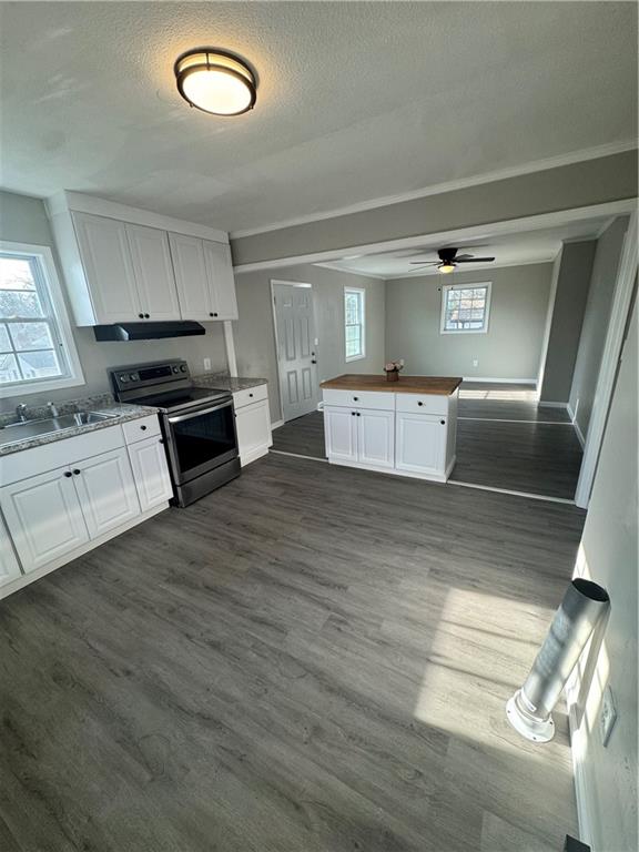 42 Busha Street Toccoa, GA 30577 - Photo 5 of 12 a large kitchen with cabinets wooden floor and stainless steel appliances