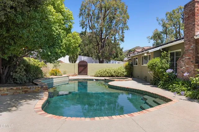 a view of a table and chairs in backyard of the house