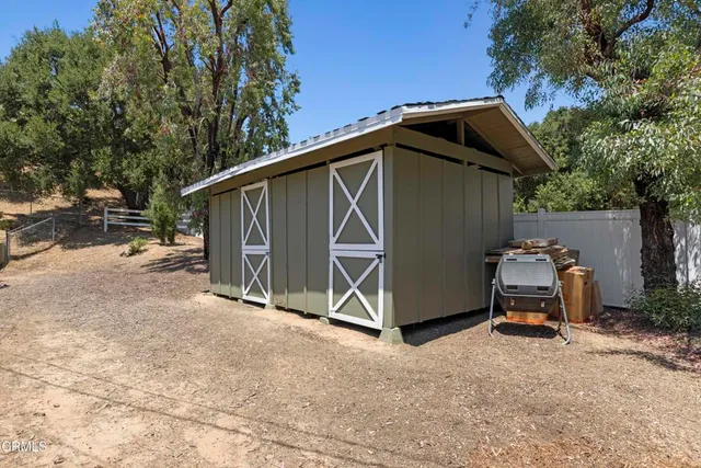 a view of backyard with table and chairs and a large tree
