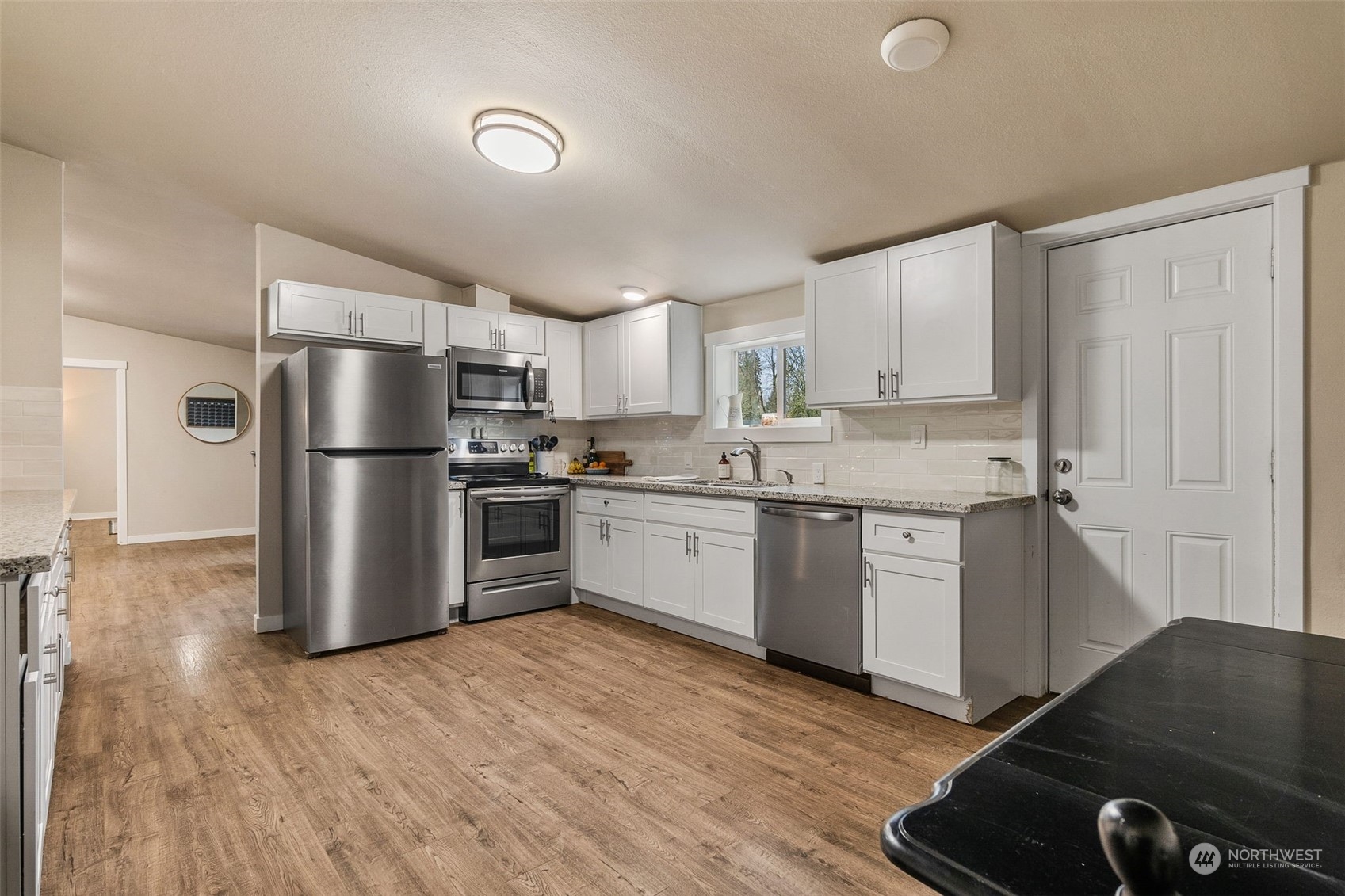 19025 Marble Street Southwest Rochester, WA 98579 - Photo 17 of 26 a kitchen with a refrigerator a stove top oven and white cabinets