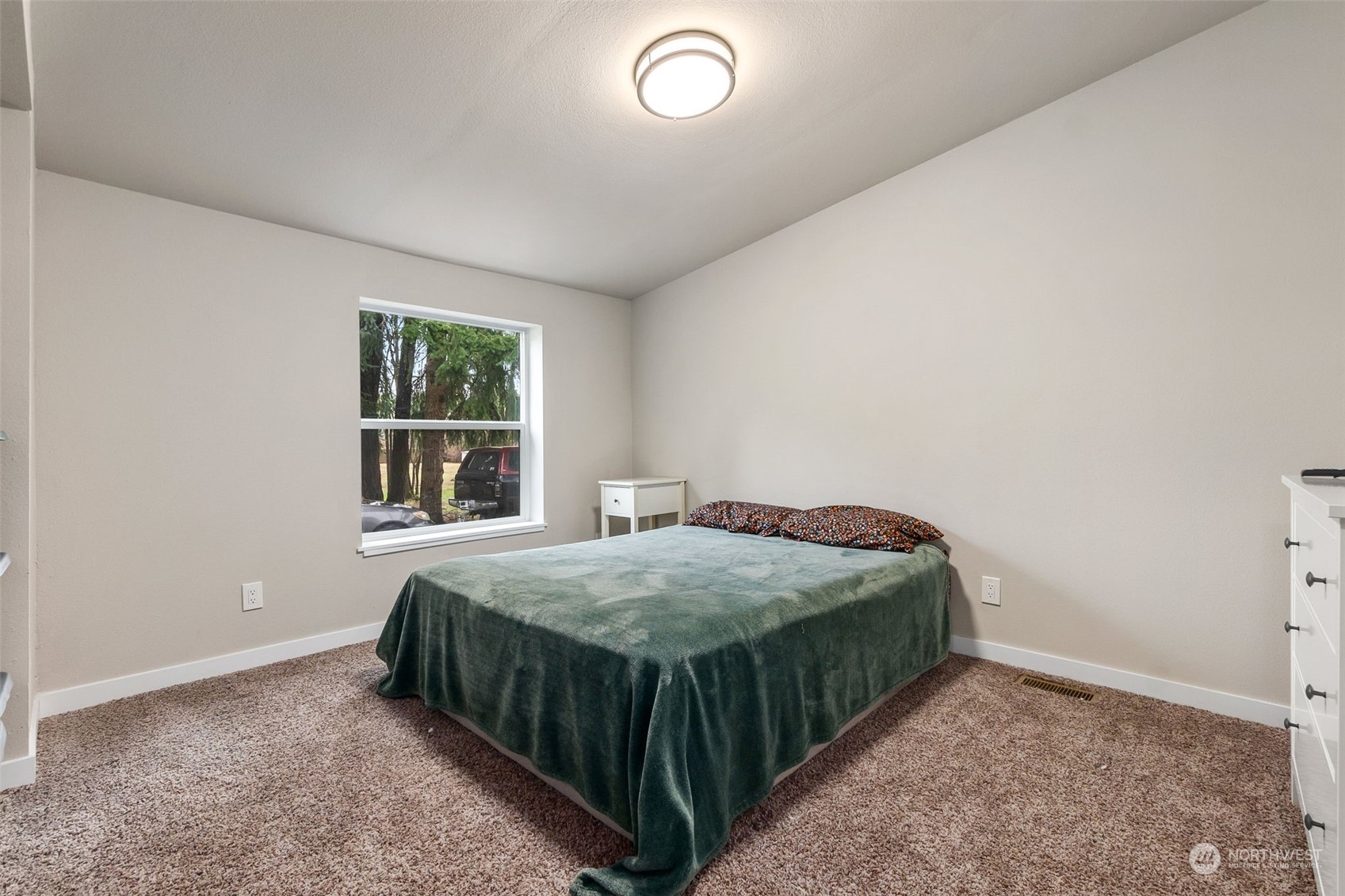 19025 Marble Street Southwest Rochester, WA 98579 - Photo 20 of 26 a bed sitting in a bedroom next to a window