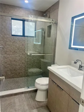 a bathroom with a sink a toilet and shower