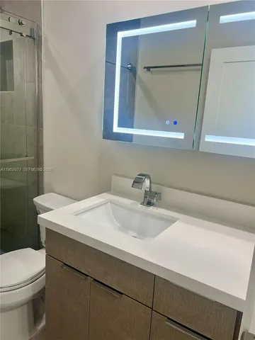 a bathroom with a sink a toilet and mirror