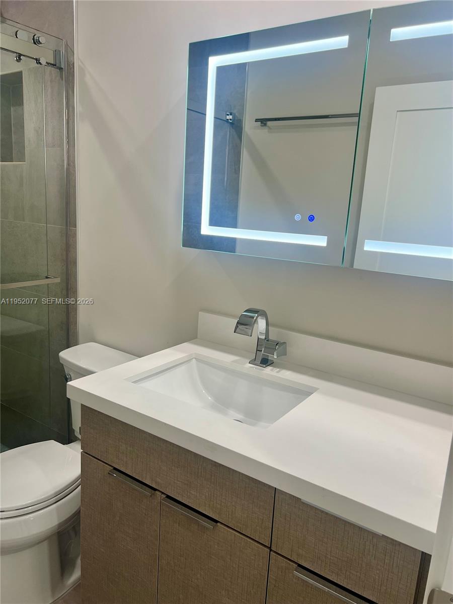3532 Thomas Avenue, Unit 3532 Miami, FL 33133 - Photo 17 of 24 a bathroom with a sink a toilet and mirror