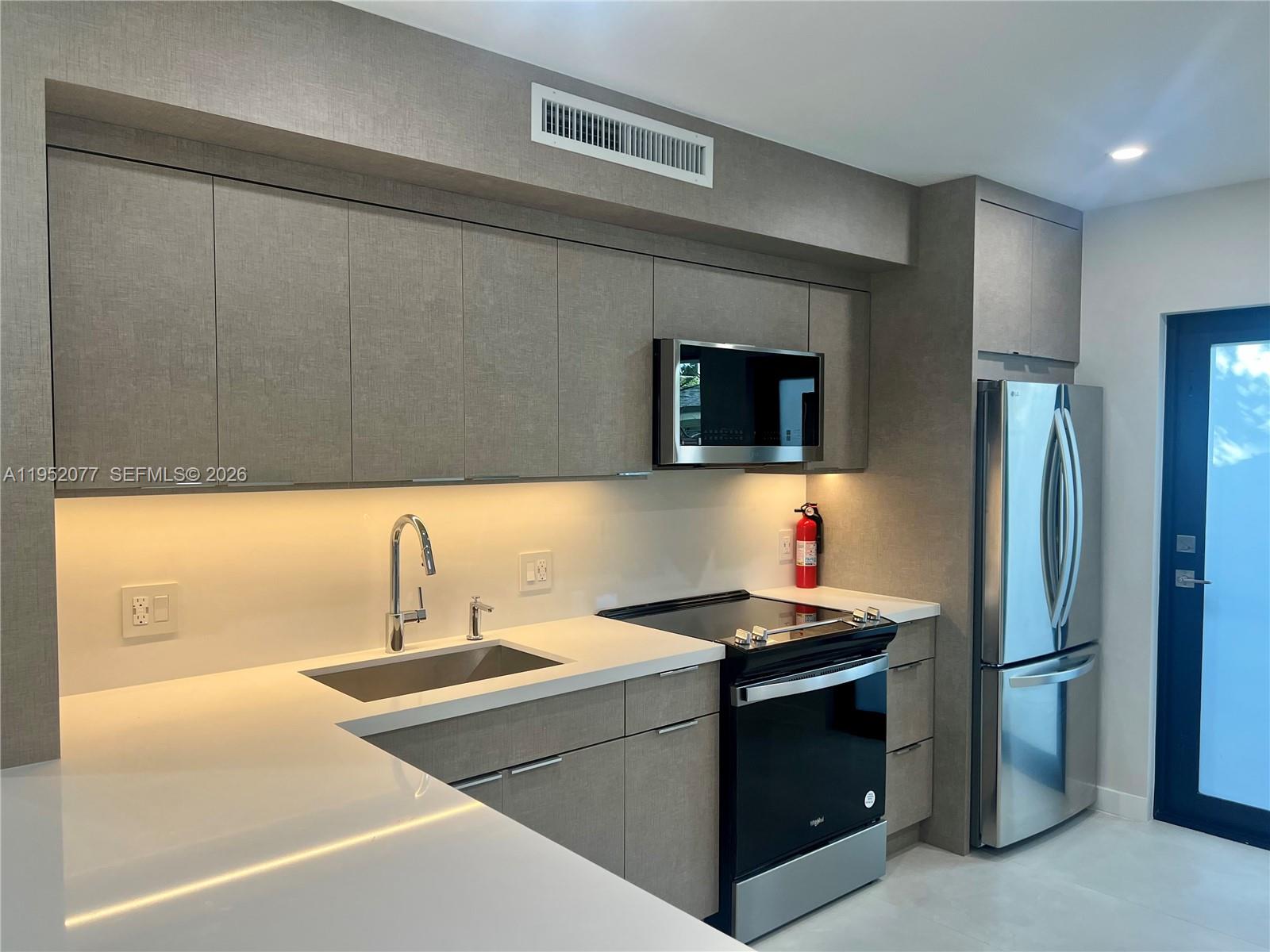 3532 Thomas Avenue, Unit 3532 Miami, FL 33133 - Photo 8 of 24 a kitchen with a sink appliances and cabinets