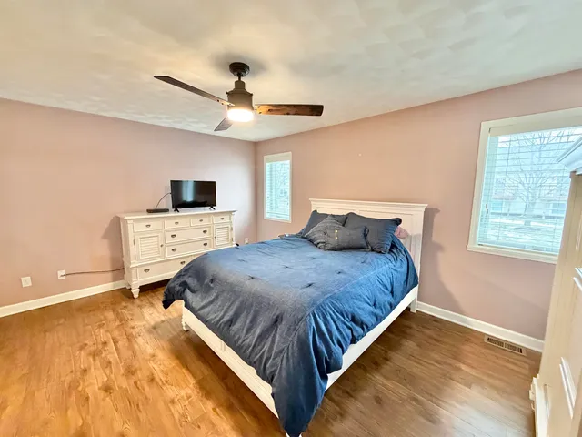 a spacious bedroom with a bed and a chandelier