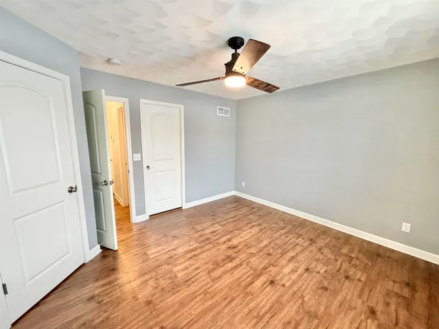 a view of empty room with wooden floor