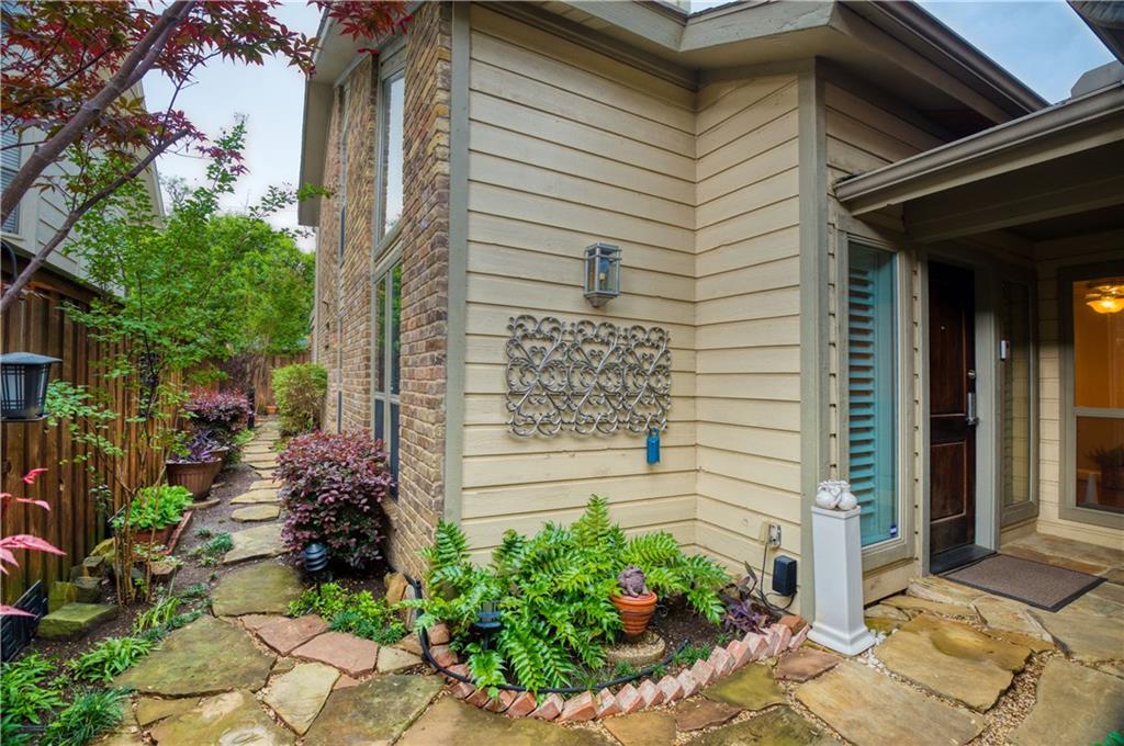 a view of a house with a yard and potted plants