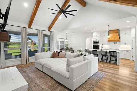 a living room with furniture a rug and kitchen view