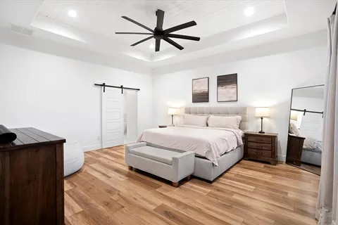 a spacious bedroom with a bed and a ceiling fan