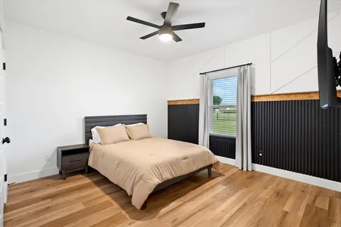 a bedroom with a large bed dresser and a window