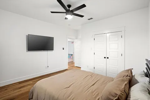 a bedroom with a bed tv and a window