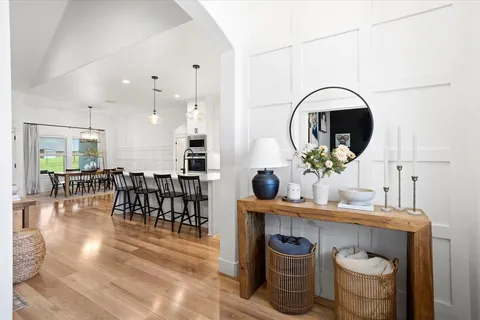 a kitchen with stainless steel appliances granite countertop a stove a sink and a dining table with wooden floor