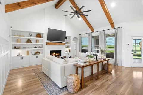 a living room with furniture a flat screen tv and a fireplace
