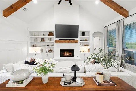 a living room with furniture a flat screen tv and a fireplace