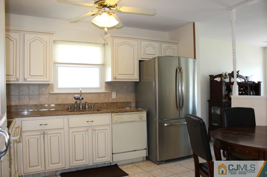 19 Rainford Road Edison, NJ 08820 - Photo 8 of 16 a kitchen with granite countertop a sink cabinets a window and stainless steel appliances