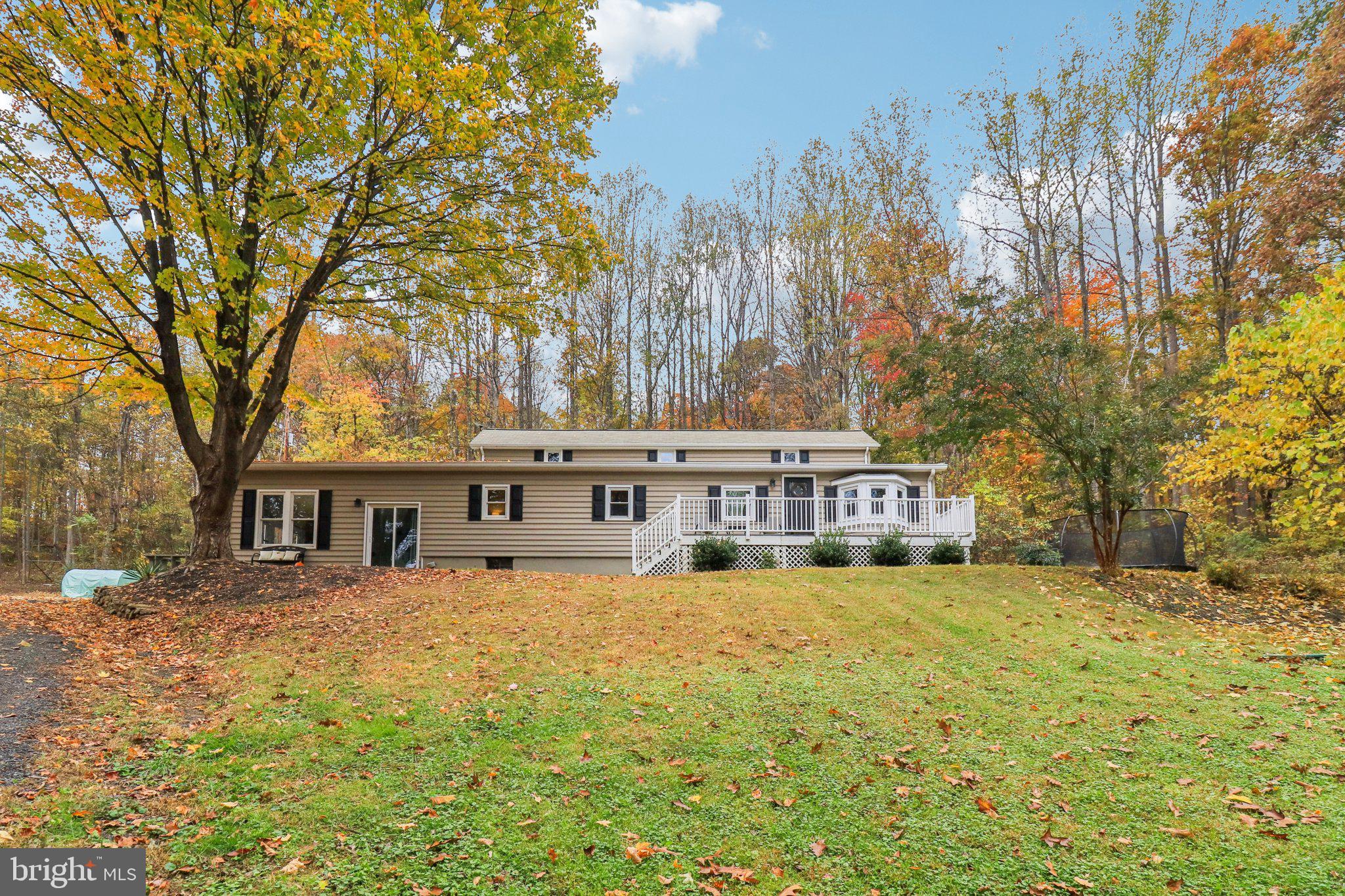 a view of a house with a big yard and large trees
