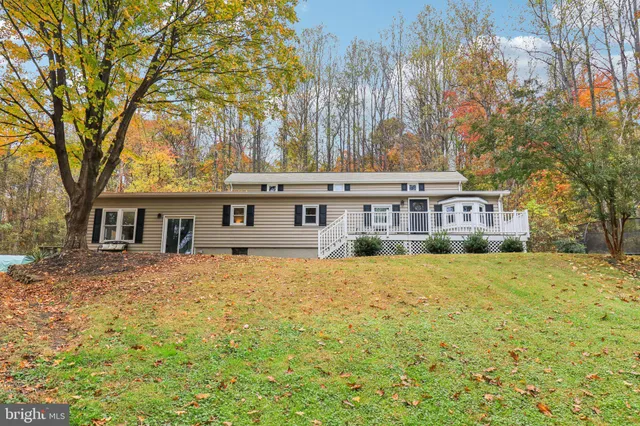 a front view of a house with a yard covered with snow and trees