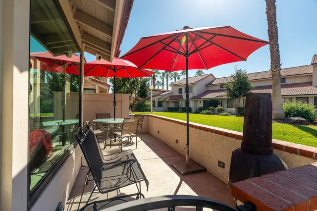 a patio with a table and chairs under an umbrella