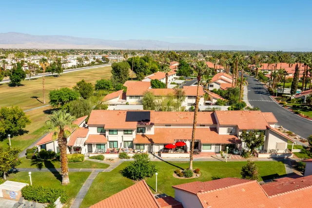 an aerial view of a house with a yard and lake view