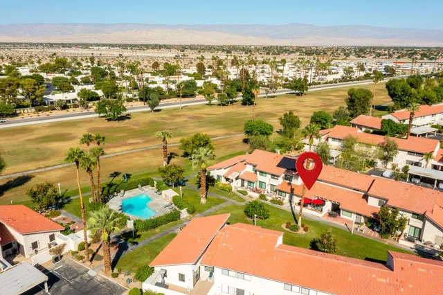 a view of a patio with table and chairs potted plants and palm trees