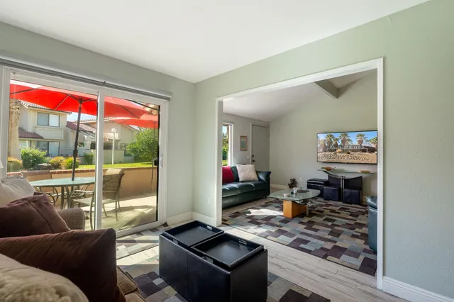 a living room with furniture a rug and a window