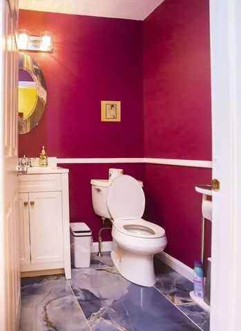 a bathroom with a toilet a sink and a mirror