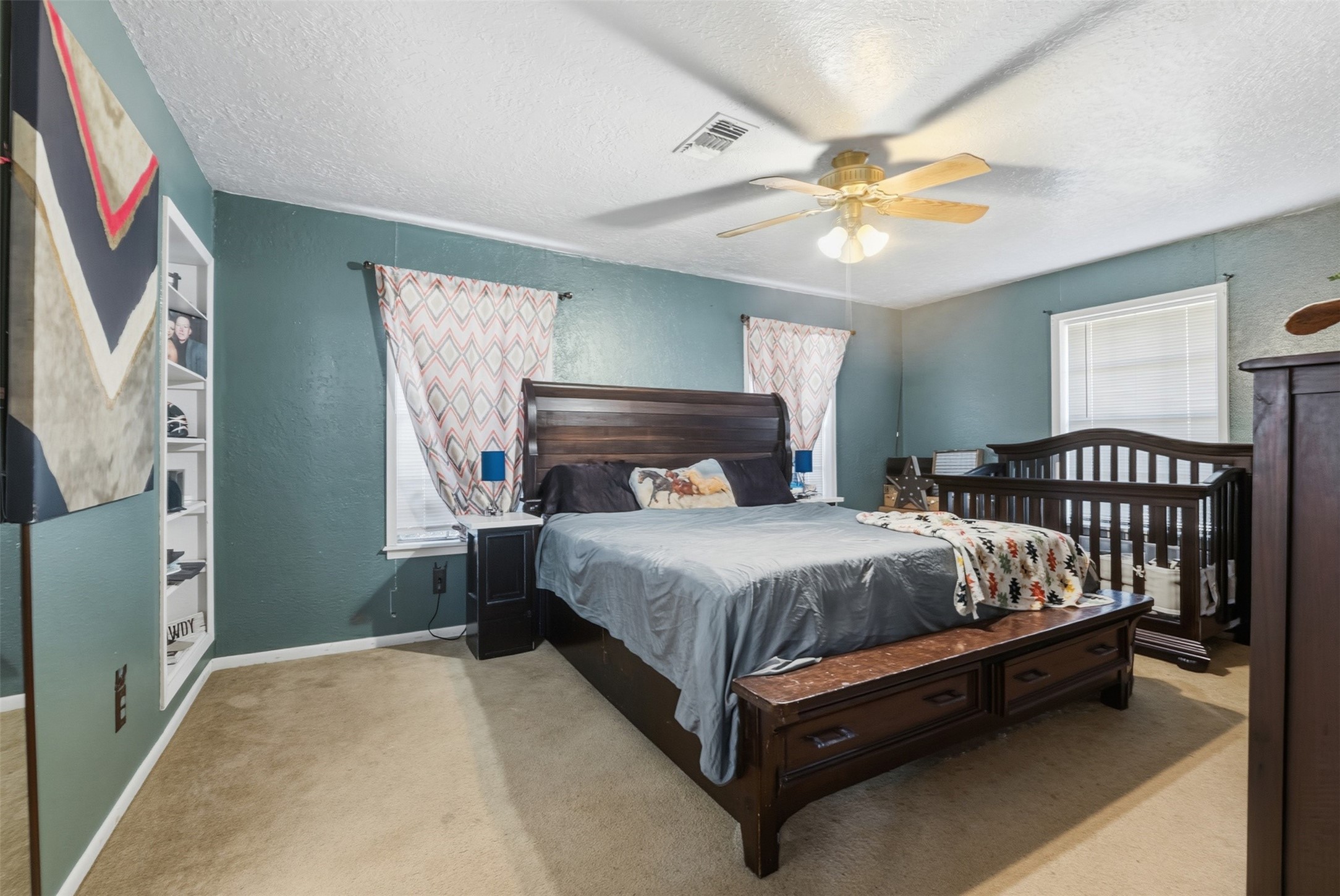 4027 Spring Branch Road Montgomery, TX 77316 - Photo 17 of 31 a bed sitting in a bedroom next to a window and a chandelier