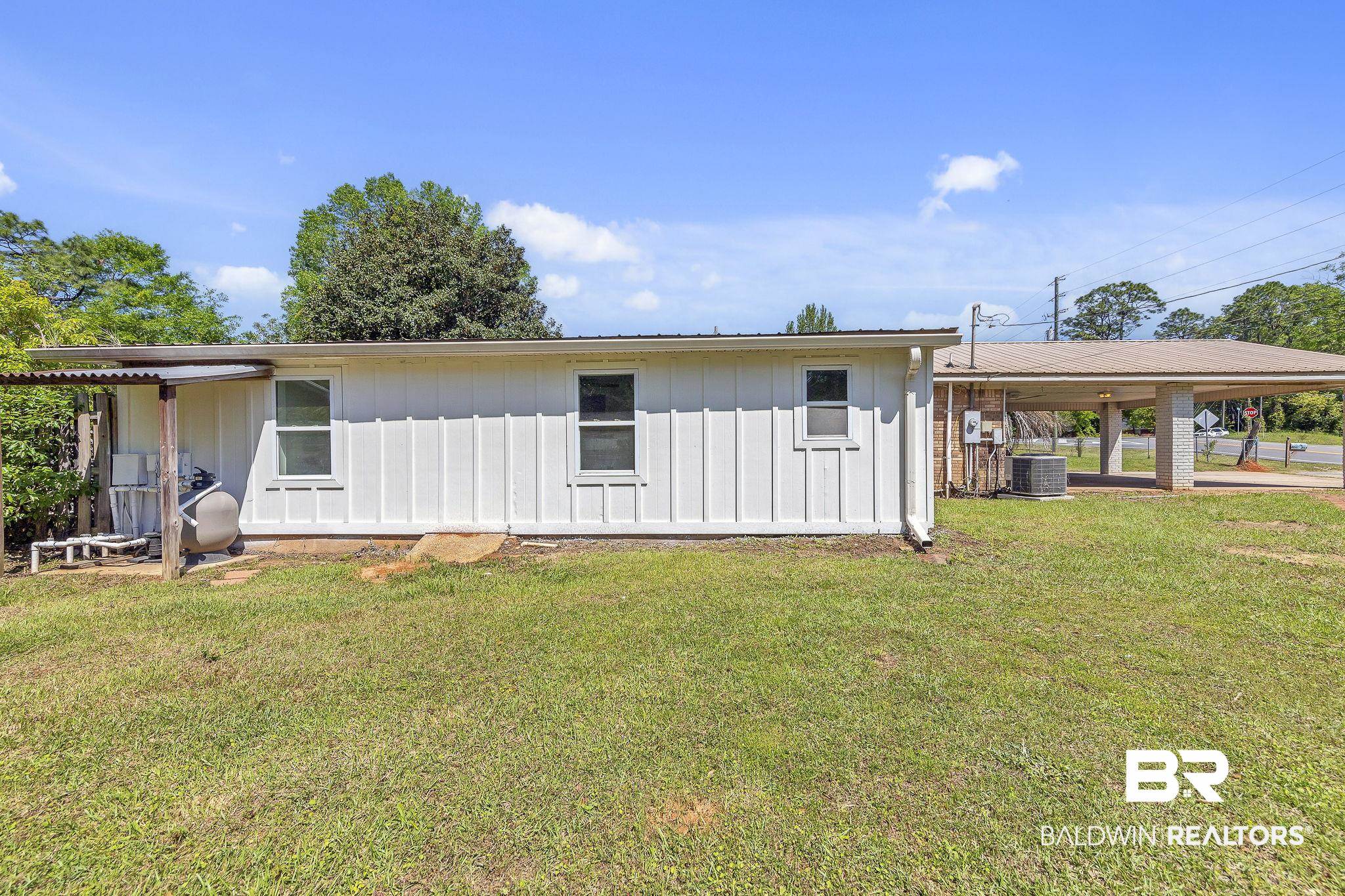 11964 Stroh Road Daphne, AL 36527 - Photo 46 of 58 Exterior space with central AC, board and batten siding, and a lawn