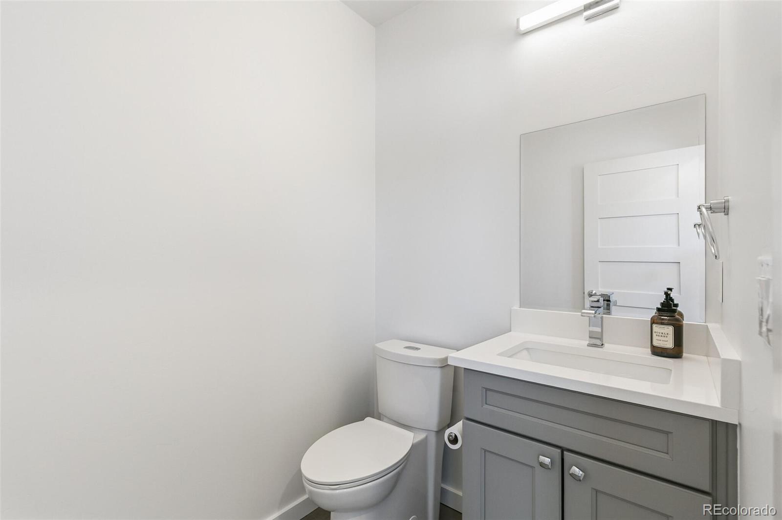 3850 West 13th Avenue Denver, CO 80204 - Photo 11 of 32 a bathroom with a toilet sink vanity and mirror