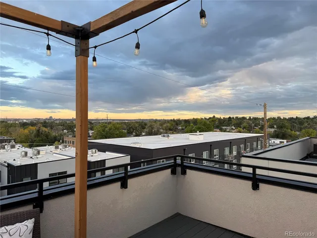 a living room with couches and a view of kitchen appliances