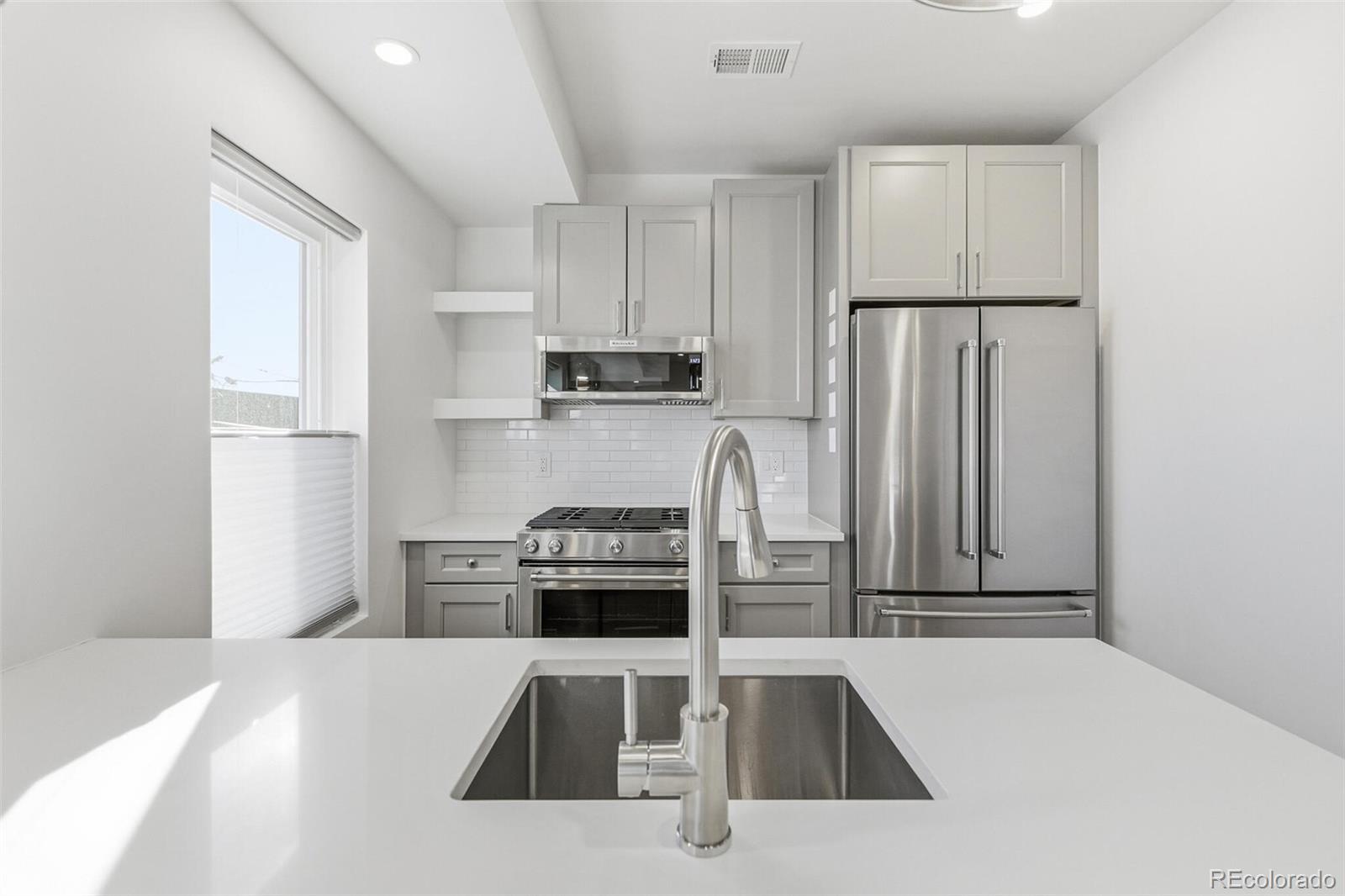 3850 West 13th Avenue Denver, CO 80204 - Photo 8 of 32 a kitchen with stainless steel appliances granite countertop a refrigerator sink and stove