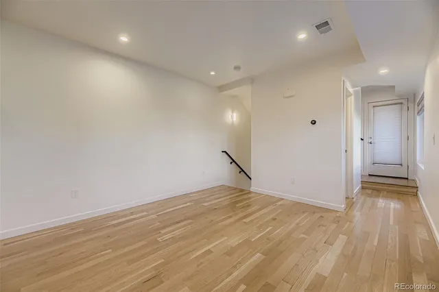 a view of empty room with wooden floor and window
