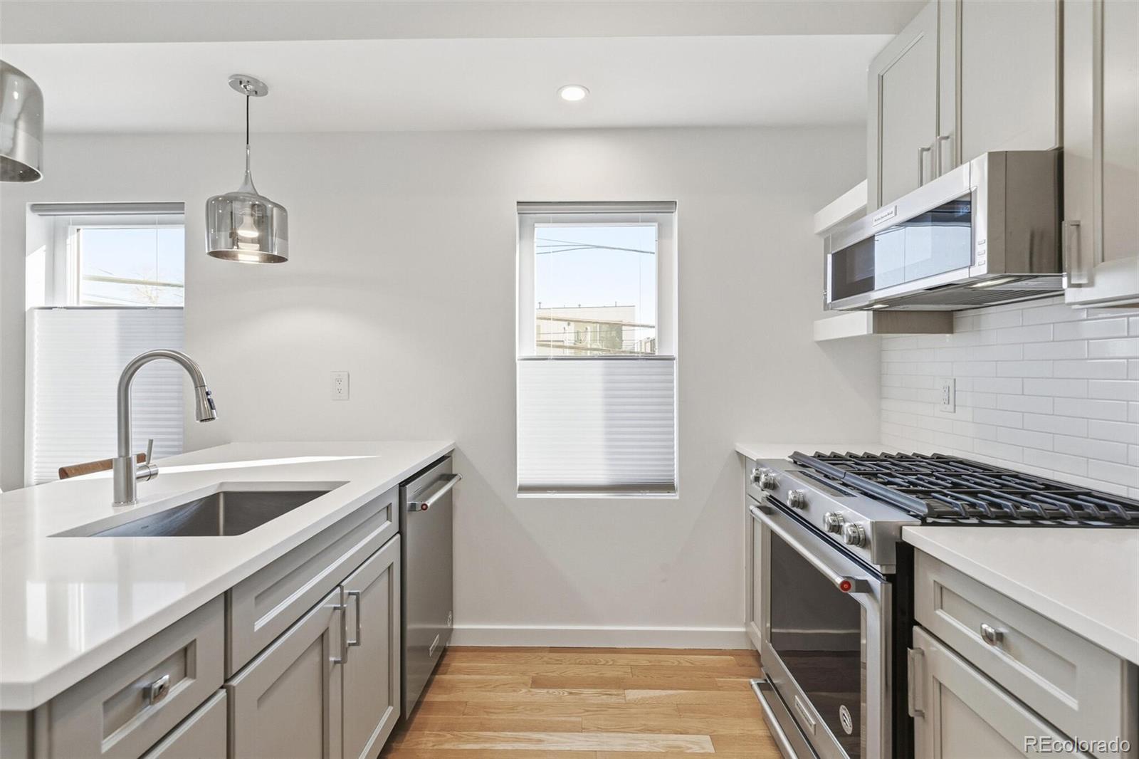 3850 West 13th Avenue Denver, CO 80204 - Photo 9 of 32 a kitchen with stainless steel appliances granite countertop a sink and a stove