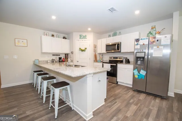 a kitchen with a sink refrigerator and microwave