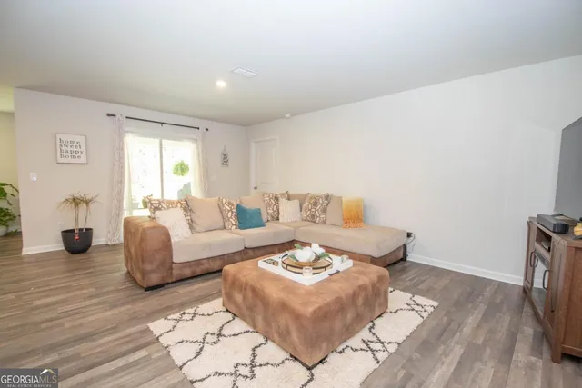 a living room with furniture and wooden floor