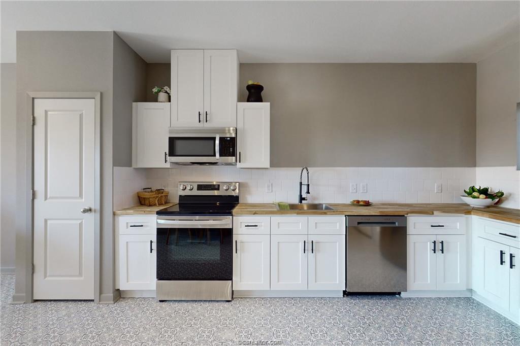101 West 33rd Street, Unit 102 Bryan, TX 77803 - Photo 3 of 11 a kitchen with stainless steel appliances granite countertop a stove and a sink