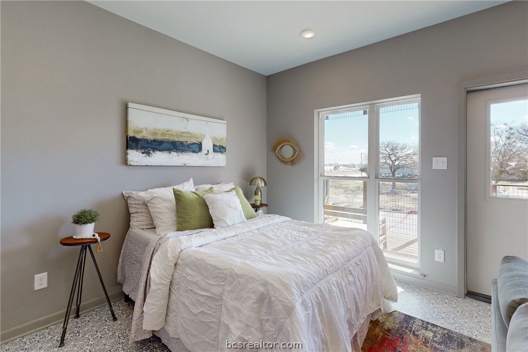101 West 33rd Street, Unit 102 Bryan, TX 77803 - Photo 9 of 11 a bedroom with a bed and a painting on the wall