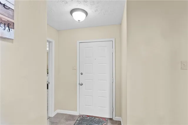 a kitchen with granite countertop a refrigerator and cabinets
