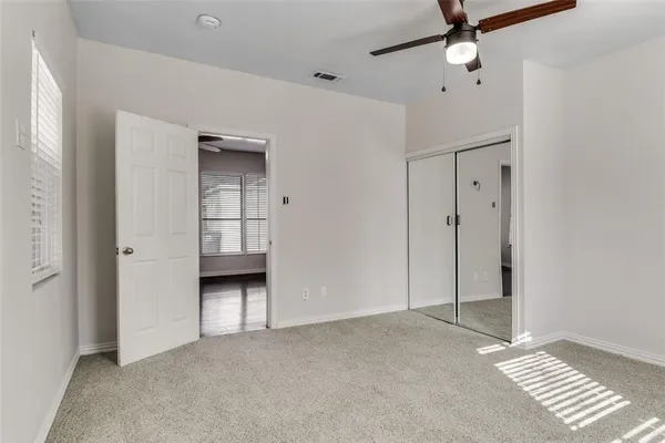 a view of an empty room with a ceiling fan