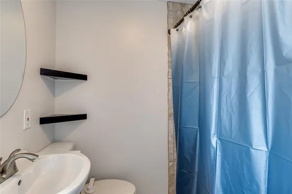 a bathroom with a sink and mirror with toilet