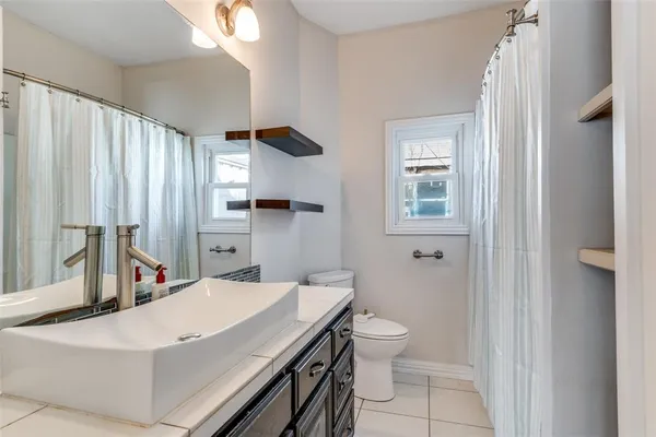 a room with a white bed desk and a bathroom