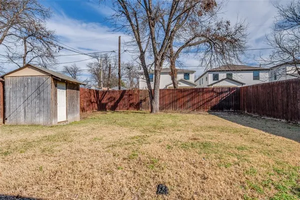 a view of a yard with wooden fence