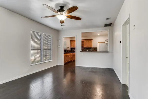 a view of a big room with wooden floor and a ceiling fan