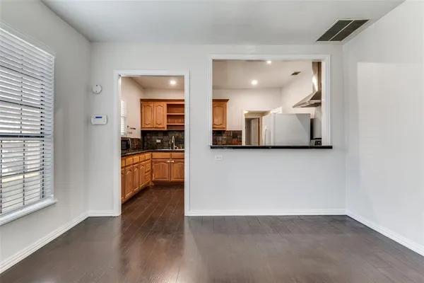 a view of a kitchen with a sink and dishwasher a stove top oven with wooden floor